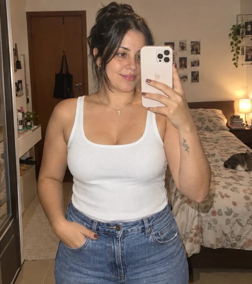 Mulher fazendo selfie com iPhone antes e depois de experimentar uma blusa